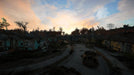 Gameplay screenshot - Post-apocalyptic suburban landscape in Fallout 4: Game of the Year Edition on PC. A ruined neighborhood with abandoned houses, rusted cars, and overgrown vegetation under a dramatic sunset sky. Experience the vast open world with your Fallout 4 GOTY CD key from RushGame.co