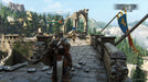 In-game screenshot of For Honor for PC showing an intense duel on a medieval stone bridge, surrounded by a stunning mountain landscape. Experience epic battles by purchasing your Ubisoft Connect CD Key at RushGame.co