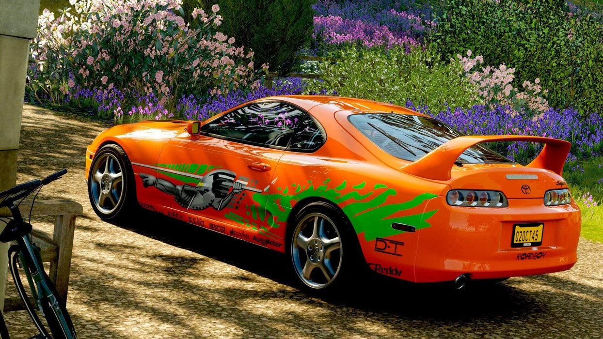 A stunning in-game shot from Forza Horizon 4 Ultimate Edition featuring an iconic Toyota Supra with a custom Fast & Furious-inspired livery parked near a vibrant garden. Get your game key at RushGame.co and drive legendary cars across dynamic seasons
