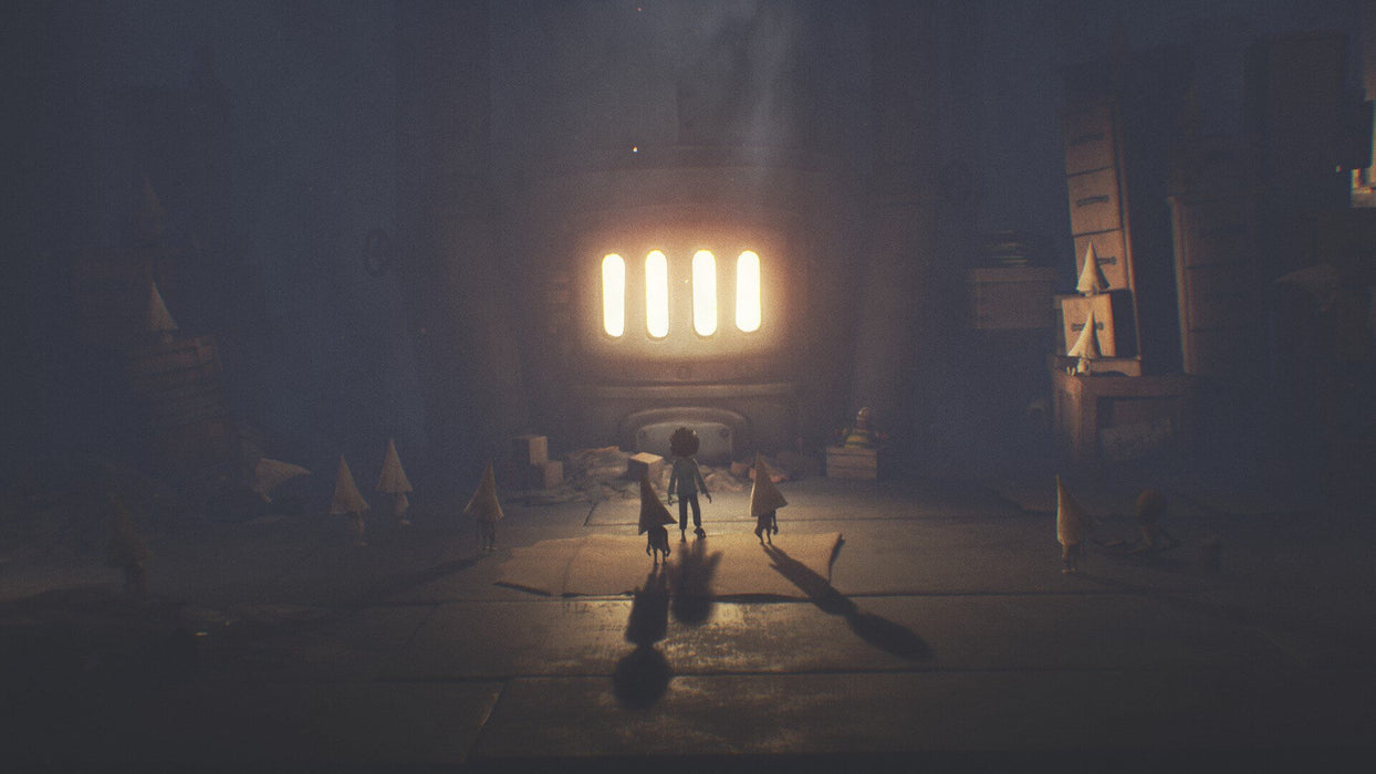 A scene from Little Nightmares Complete Edition on PC, showing a child-like character standing in a dark room, gazing at a brightly lit furnace, surrounded by small, mysterious creatures with cone-shaped heads.