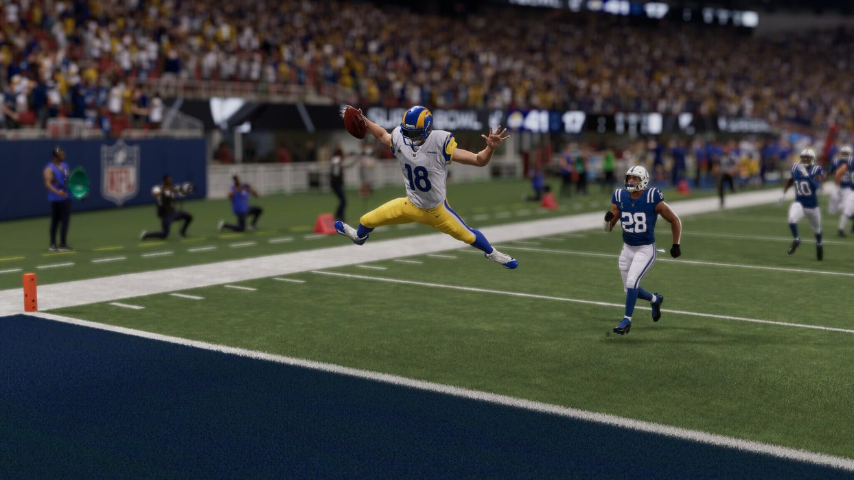 An exciting scene from Madden NFL 24 Deluxe Edition on PS4/PS5, showing a Rams player leaping towards the end zone with defenders in pursuit. Get your Madden NFL 24 Deluxe Edition PS4/PS5 game key now at RushGame.co