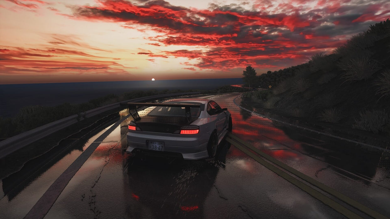 A white Nissan Silvia with a massive rear wing drifts along a winding mountain road under a dramatic red sunset. Master the art of drifting in Assetto Corsa: Ultimate Edition. Secure your Steam CD key today at RushGame.co