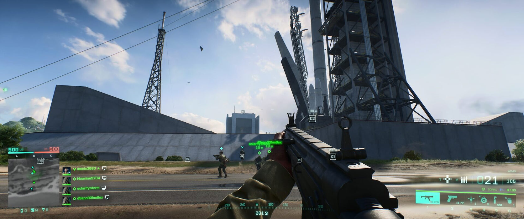 A massive industrial battle in Battlefield 2042, with soldiers advancing toward a towering rocket launch facility.