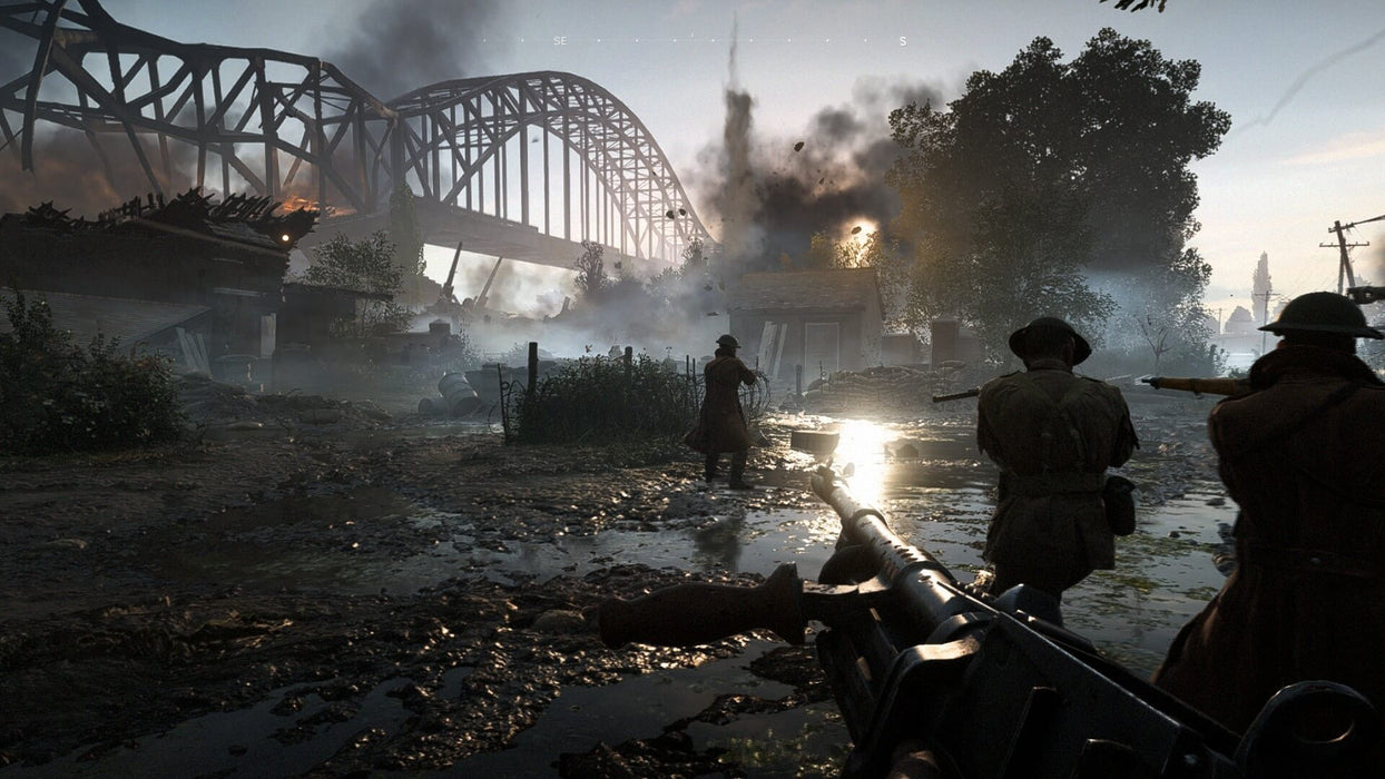 A dramatic battle scene in Battlefield V, depicting soldiers advancing through a war-torn European village with a large metal bridge in the background. Explosions and gunfire illuminate the battlefield. Buy your digital game key at RushGame.co