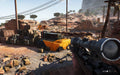 A sniper's perspective in Battlefield V, overlooking a desert outpost filled with supply crates and sandbags, ready for a long-range engagement. Experience realistic WWII combat with an EA Play Origin CD Key from RushGame.co