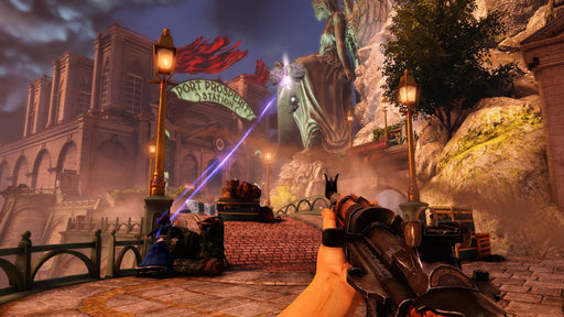 A stunning in-game screenshot from BioShock Infinite on PC, featuring the player's first-person perspective as they aim a rifle in the floating city of Columbia. The environment is filled with grand architecture, glowing street lamps, and a mysterious energy beam illuminating the area. Available now at RushGame.co