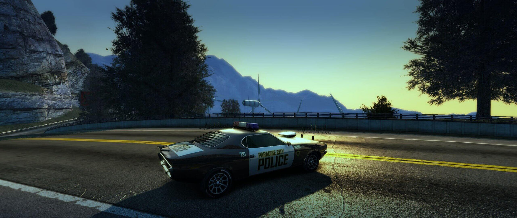 Screenshot – Police muscle car patrolling the scenic roads of Paradise City in Burnout Paradise Remastered. Buy your Xbox Series X|S key for instant activation at RushGame.co