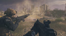 Tactical Combat in Open Terrain – A first-person perspective of a soldier aiming his weapon while another teammate prepares for battle in a dusty battlefield with urban structures in the distance. Secure your Modern Warfare III Cross-Gen Bundle key at RushGame.co and experience high-intensity warfare with realistic combat mechanics.