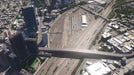 Gameplay screenshot: A high-angle aerial shot of a bustling city with a major transportation hub, including railway tracks and train depots, demonstrating the game's detailed simulation. Secure your Cities: Skylines Complete Edition CD Key for PC at RushGame.co and design complex city layouts with advanced transit systems.