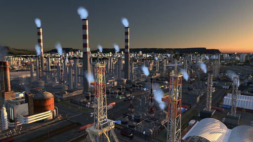 Game screenshot: A detailed industrial district in Cities: Skylines - Industries DLC, showcasing multiple factories with smokestacks releasing steam into the evening sky. Buy your Cities: Skylines Industries DLC CD Key at RushGame.co for seamless activation