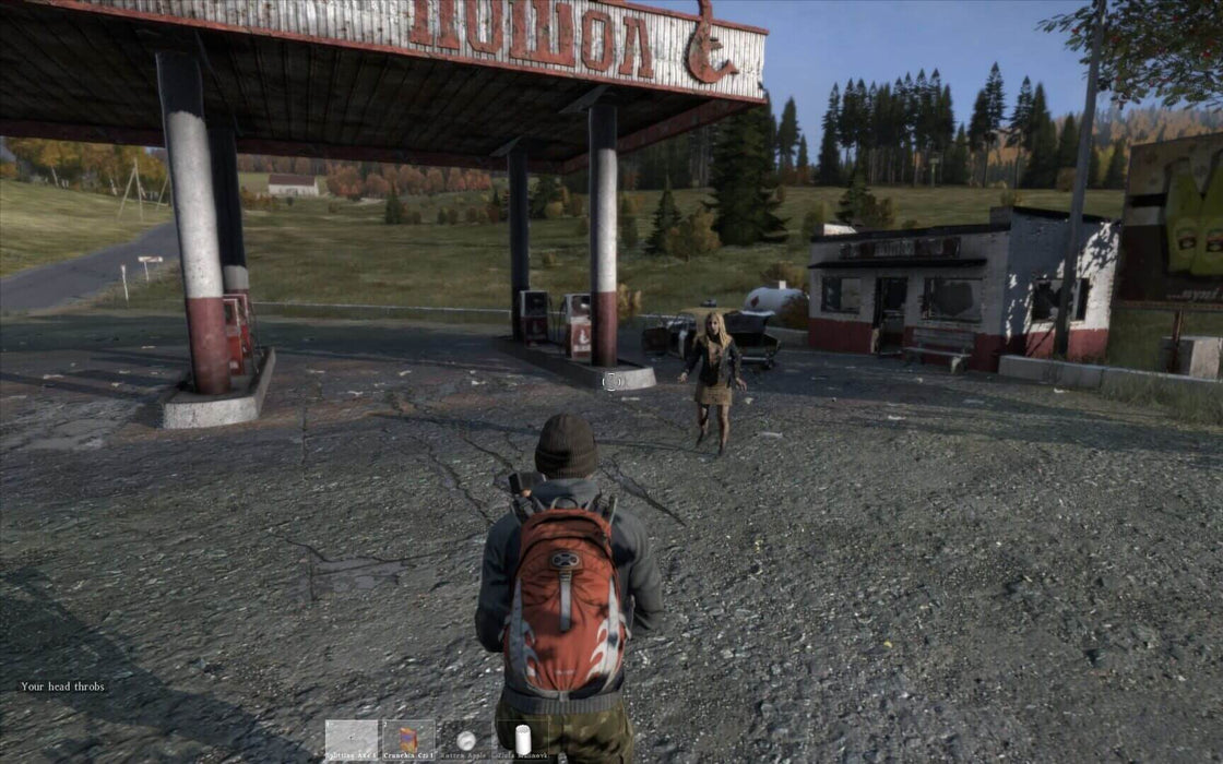 gameplay screenshot: A player-controlled survivor in DayZ approaches a dilapidated gas station, facing an approaching infected enemy. The eerie setting, complete with abandoned structures and signs of past civilization, highlights the hostile world of DayZ. Buy the game now at RushGame.co for an intense survival challenge