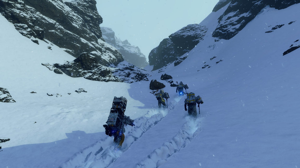 Snowy Mountains): "Gameplay screenshot of Death Stranding: Director's Cut featuring Sam Porter Bridges and other porters trekking through a treacherous, snow-covered mountain pass. The deep snow and dynamic weather effects showcase the game's realistic terrain traversal. Buy your Steam CD Key now at RushGame.co