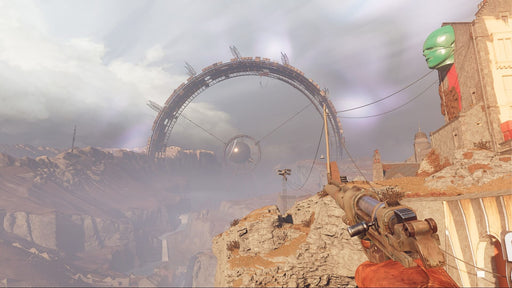 gameplay screenshot Sniper view of a futuristic structure in Deathloop – A first-person view of a character aiming a sniper rifle at a massive, mysterious ring-like structure in a barren landscape. The eerie, sci-fi atmosphere defines the immersive world of Deathloop. Get the PC Steam key at RushGame.co