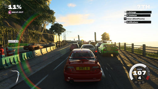 In-game screen action from DIRT 5, depicting a rally race at sunset with cars speeding through a scenic mountainous track, highlighting the game’s immersive lighting and terrain effects. Get your digital copy at RushGame.co