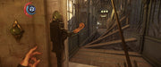 A tense gameplay moment from Dishonored 2 on Xbox One, showing a player activating a mechanism inside an eerie mechanical structure. Experience dynamic stealth-action gameplay by getting your Dishonored 2 CD key at RushGame.co