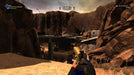 First-person gameplay from Duke Nukem Forever on PC Steam, showcasing a vast desert canyon with a collapsed bridge, abandoned vehicles, and the player wielding a golden pistol. Buy your Steam CD Key now at RushGame.co