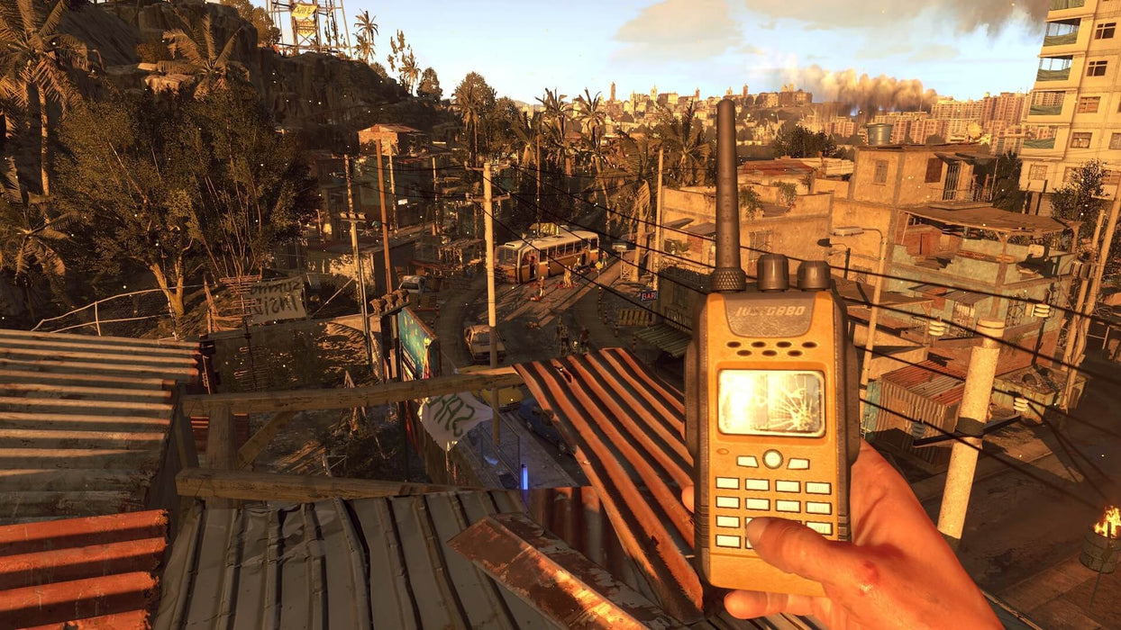 In game screenshot - "A player holds a cracked walkie-talkie on a sunlit rooftop, overlooking a decayed urban slum in Dying Light: Definitive Edition. Communicate with allies and survive the horrors of Harran in this ultimate zombie experience. Buy your PC Steam CD Key now at RushGame.co