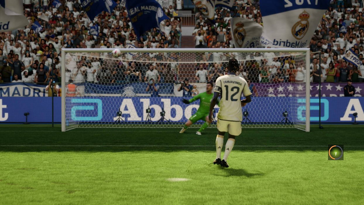 Game screenshot - A penalty kick moment in EA SPORTS FC 24, with Real Madrid’s Eduardo Camavinga preparing to shoot. The crowd, banners, and goalkeeper animations bring realism to the game. Get your EA Play CD Key for PC now at RushGame.co