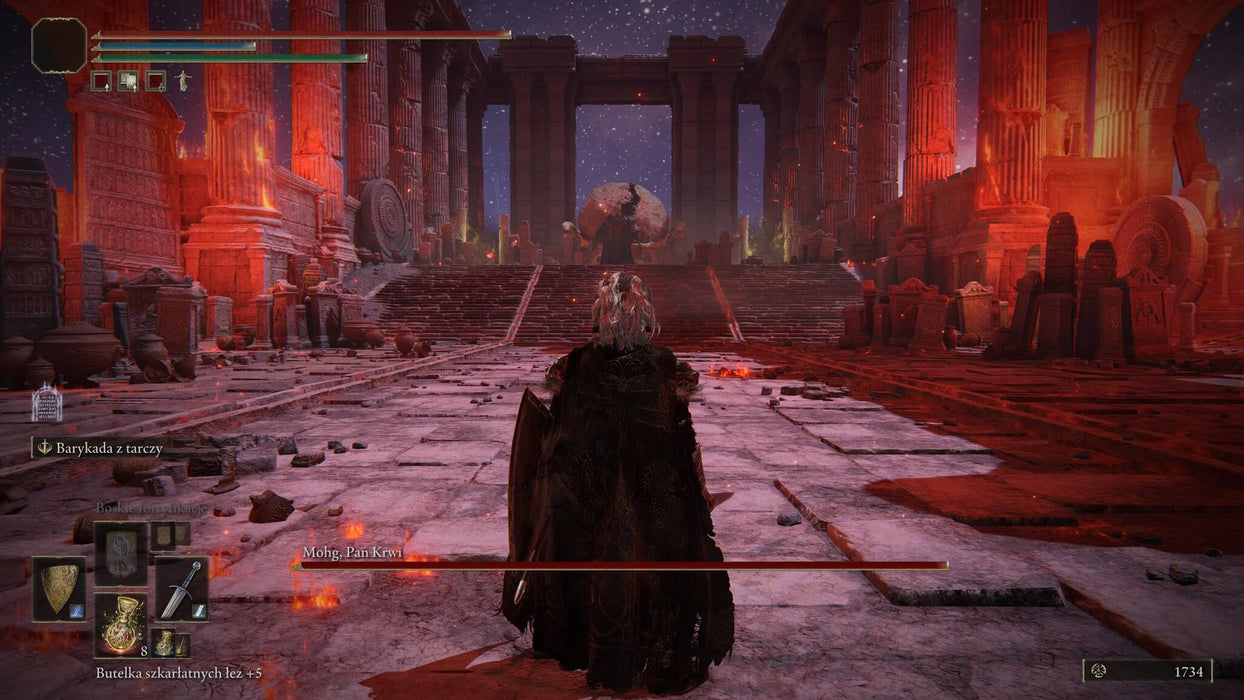 Gameplay screen - A lone warrior stands before the towering, red-lit ruins in Elden Ring Deluxe Edition on Steam, preparing for an epic boss fight against Mohg, Lord of Blood. Purchase your digital key today at RushGame.co