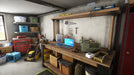 Gameplay screenshot - An immersive in-game view from Electrician Simulator, showcasing a cluttered garage workshop filled with electrical tools and components. Perfect for players who enjoy realistic repair simulations. Purchase your Steam key today at RushGame.co