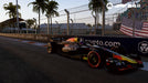 F1 24 in-game screenshot capturing a Red Bull Racing car on the Miami Grand Prix track, surrounded by palm trees and an American flag in the background. Buy your F1 24 Default Title & Default Title CD Key at RushGame.co and race on iconic circuits worldwide