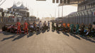 F1 24 gameplay screenshot showing the full lineup of Formula 1 drivers standing in front of their cars on the starting grid, illuminated by the golden sunset. Get your F1 24 Default Title & Default Title CD Key at RushGame.co and experience the thrill of competitive racing with the best drivers in the world