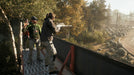 Gameplay screenshot - Tactical gameplay in Far Cry 5 on Xbox One, featuring a sniper aiming from an elevated position while allies prepare for an ambush in the wilderness of Hope County. Buy your Xbox One CD Key US now at RushGame.co and take down the Eden’s Gate cult