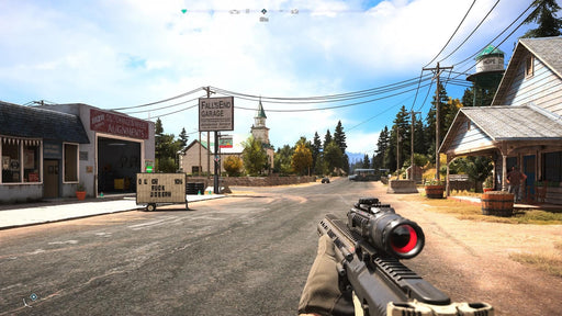 Far Cry 5 Xbox One gameplay screenshot showcasing a first-person view in Fall’s End, a small town in Hope County, with a scoped rifle aimed at the streets. Get your Xbox One CD Key US now at RushGame.co and fight back against the cult’s reign