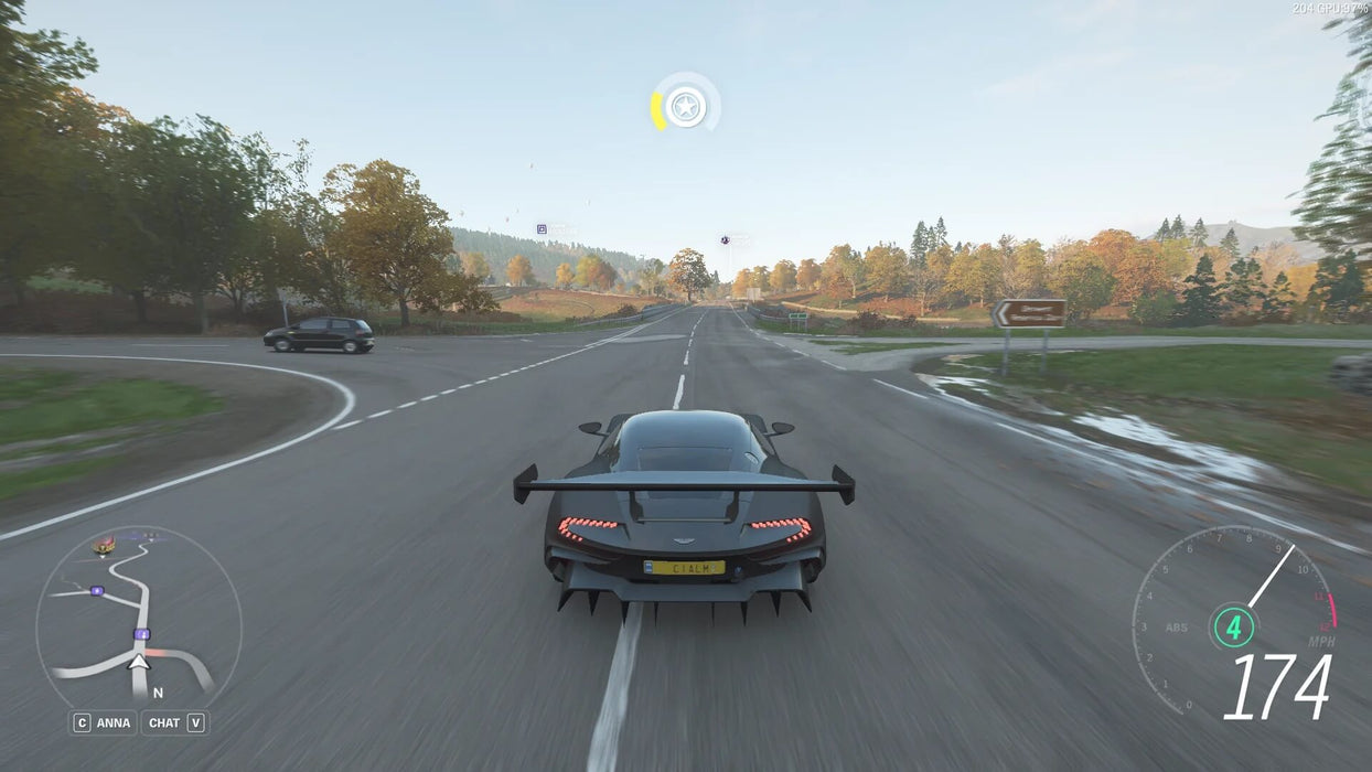 Gameplay screenshot - A sleek black Aston Martin Vulcan speeds along an open highway in Forza Horizon 4 Standard Edition. Enjoy high-speed racing in stunning seasonal environments. Get your digital game key at RushGame.co!