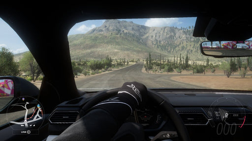 Gameplay screenshot - A first-person driving view in Forza Horizon 5 Deluxe Edition, showcasing the immersive cockpit perspective as a driver navigates through the vast Mexican landscape. Get your game key at RushGame.co and enjoy the most immersive racing experience with realistic handling and visuals