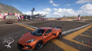 Gameplay screenshot - An orange Chevrolet Corvette C8 parked at the Horizon Festival in Forza Horizon 5 Deluxe Edition, ready to race against top competitors. Buy your digital activation key at RushGame.co and customize high-performance cars in stunning detail
