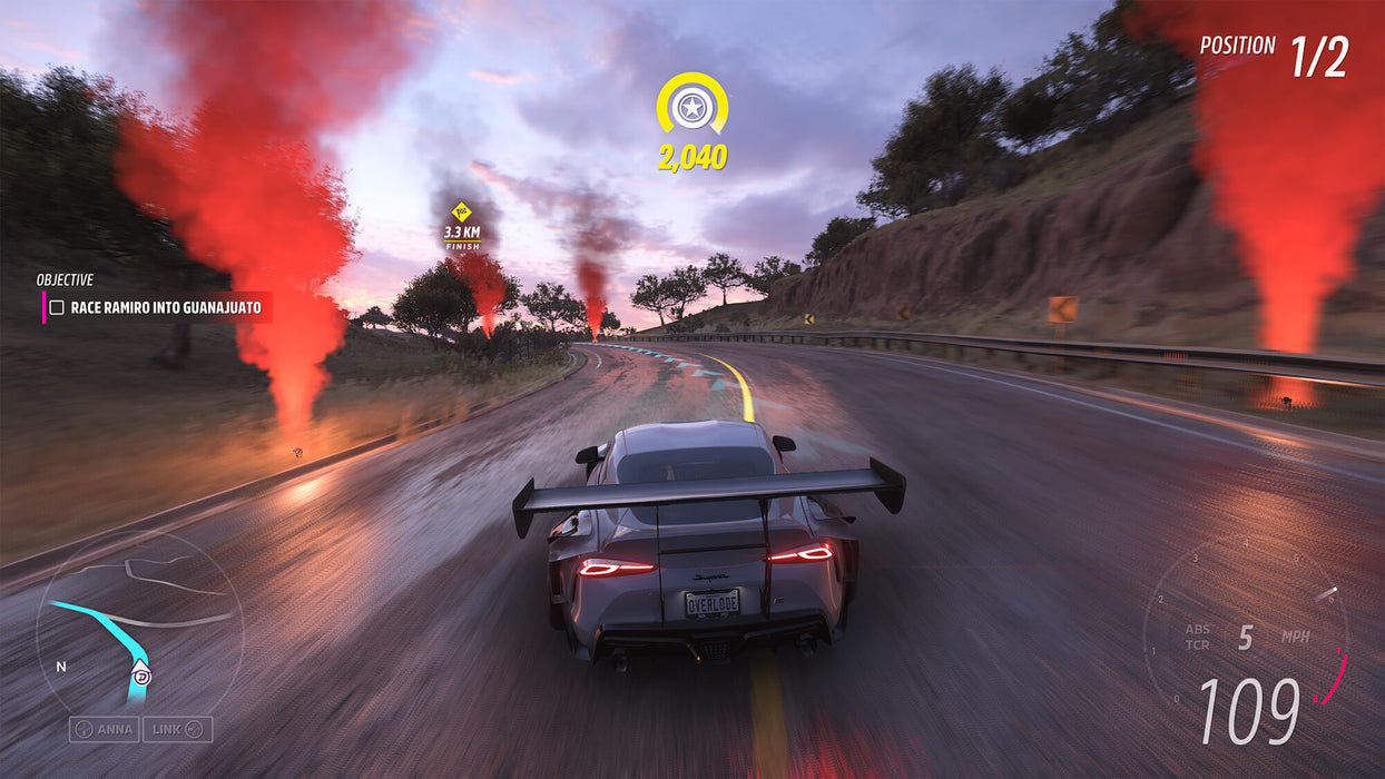 Gameplay screenshot - A Toyota Supra with a massive rear spoiler racing towards Guanajuato in Forza Horizon 5 Premium Add-Ons Bundle DLC, surrounded by dramatic red smoke trails. Get your instant game key at RushGame.co and take on the Horizon Festival's biggest challenges
