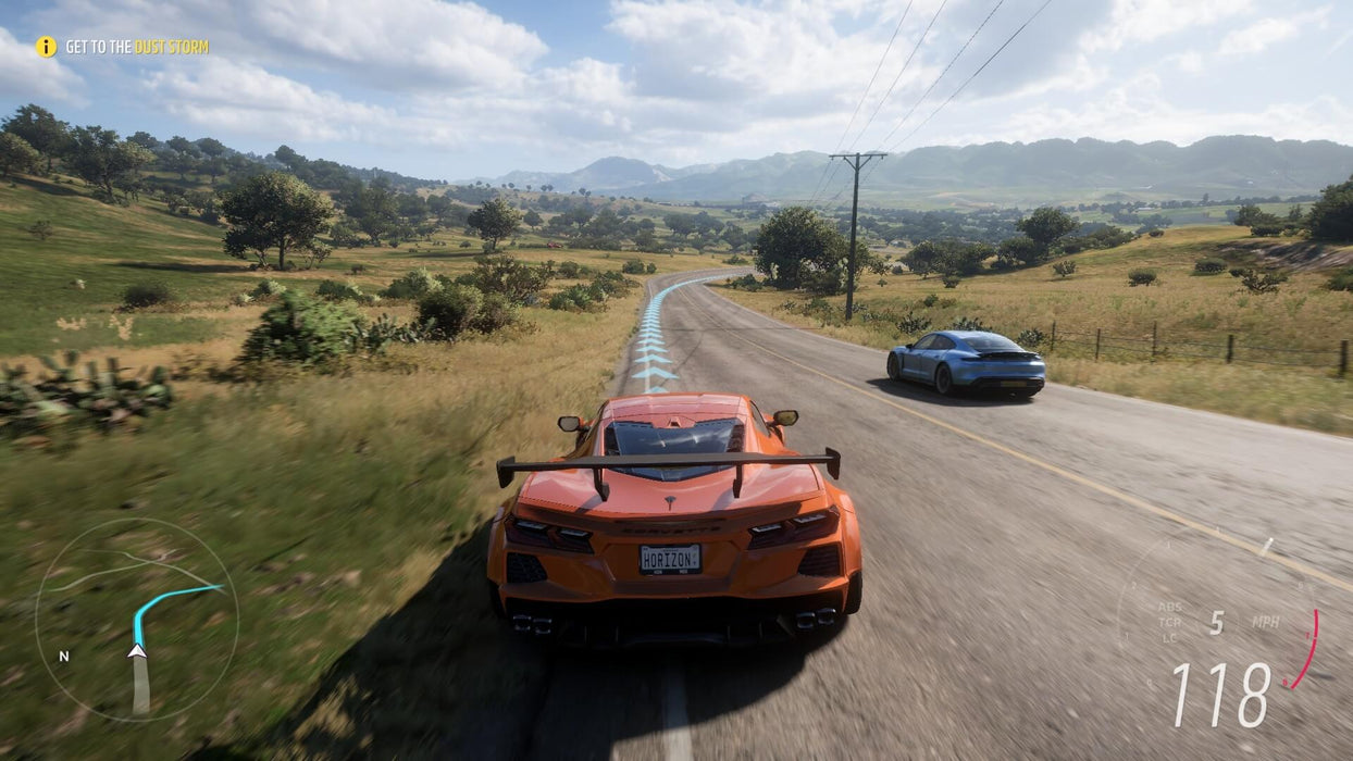Gameplay screenshot - A high-speed race in Forza Horizon 5, featuring an orange Corvette C8 and a blue Porsche speeding through the scenic countryside. Get your Forza Horizon 5 Standard Edition Xbox and PC game key at RushGame.co and experience breathtaking open-world racing