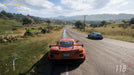 Gameplay screenshot - A high-speed race in Forza Horizon 5, featuring an orange Corvette C8 and a blue Porsche speeding through the scenic countryside. Get your Forza Horizon 5 Standard Edition Xbox and PC game key at RushGame.co and experience breathtaking open-world racing