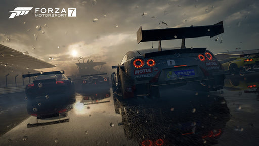 Gameplay screenshot - A thrilling rain-soaked race in Forza Motorsport 7, featuring multiple GT-class cars battling on a wet track with detailed reflections and weather effects. Get your Forza Motorsport 7 Deluxe Edition Xbox and PC key at RushGame.co and race like a pro