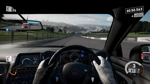 Gameplay screenshot - First-person cockpit view from a Nissan GT-R racing downhill in Forza Motorsport 7, with a competitor in the rearview mirror. Get your Forza Motorsport 7 Standard Edition digital key now at RushGame.co and master every turn on the track