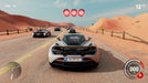 Gear.Club Unlimited 2 Ultimate Edition gameplay screenshot showing a McLaren supercar at the starting line of a desert race with multiple opponents. The race countdown lights indicate the action is about to begin. Buy your Gear.Club Unlimited 2 Ultimate Edition PC Steam CD Key at RushGame.co and dominate the tracks