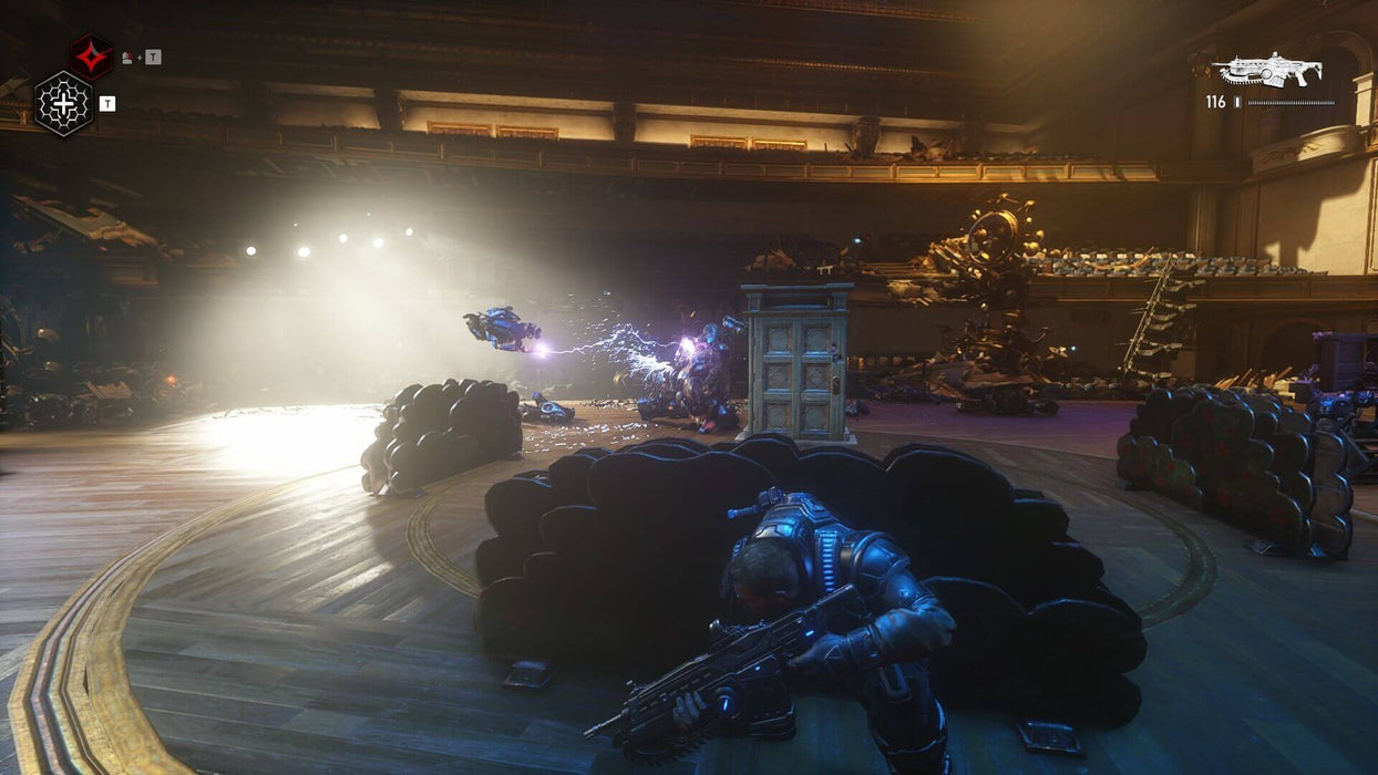 Gears 5 gameplay screenshot showing a player taking cover in a theater while engaging in an intense battle against robotic enemies with electrifying effects. Master tactical combat—get your Gears 5 Game of the Year Edition key at RushGame.co