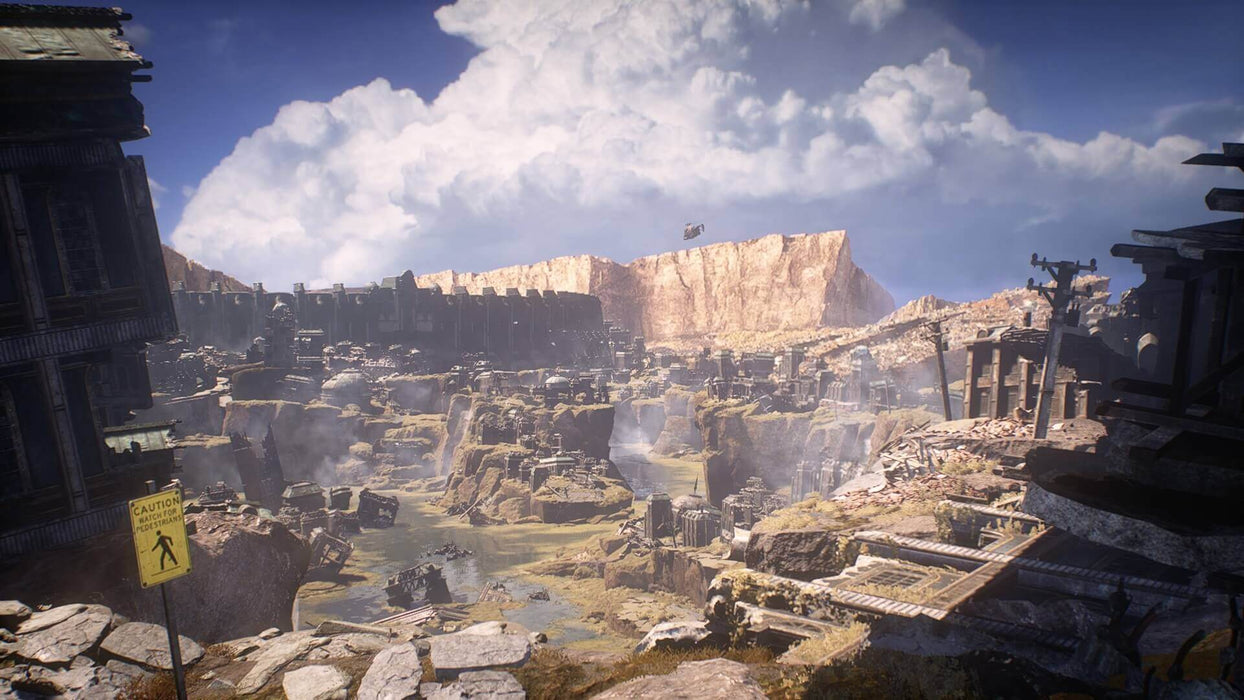 Gameplay screen - A breathtaking ruined cityscape from Gears 5, featuring crumbling buildings, debris, and a desolate canyon under a cloudy sky. Explore intense environments and engage in thrilling combat—buy your Gears 5 Game of the Year Edition key at RushGame.co