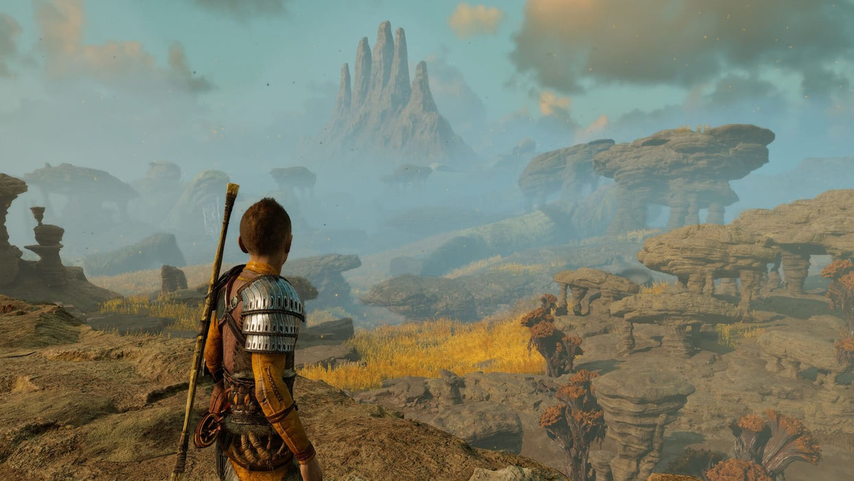 Gameplay screenshot - Atreus gazes over a vast rocky landscape with towering peaks in God of War Ragnarök on PS5. Embark on a mythological journey—purchase your CD Key US at RushGame.co