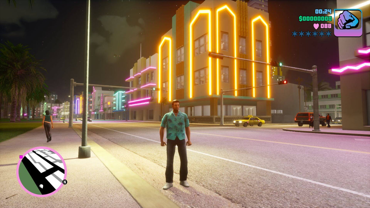 Gameplay screenshot - Nighttime street view in Grand Theft Auto: Vice City - The Definitive Edition on Xbox One, with Tommy Vercetti standing near neon-lit buildings and classic cars. Grab your GTA Trilogy Xbox One CD Key instantly at RushGame.co