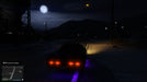 Gameplay screenshot - A black muscle car cruises through the countryside under the moonlit sky in Grand Theft Auto V for Xbox One. Experience immersive night driving and an expansive open world—get your GTA V CD Key at RushGame.co