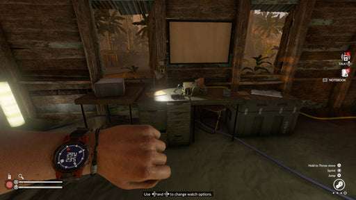 Green Hell PC Steam gameplay scene inside a makeshift jungle shelter, featuring a player's wristwatch displaying vitals and a cluttered workstation. Stay alive in the unforgiving wilderness—buy your Green Hell activation key instantly at RushGame.co