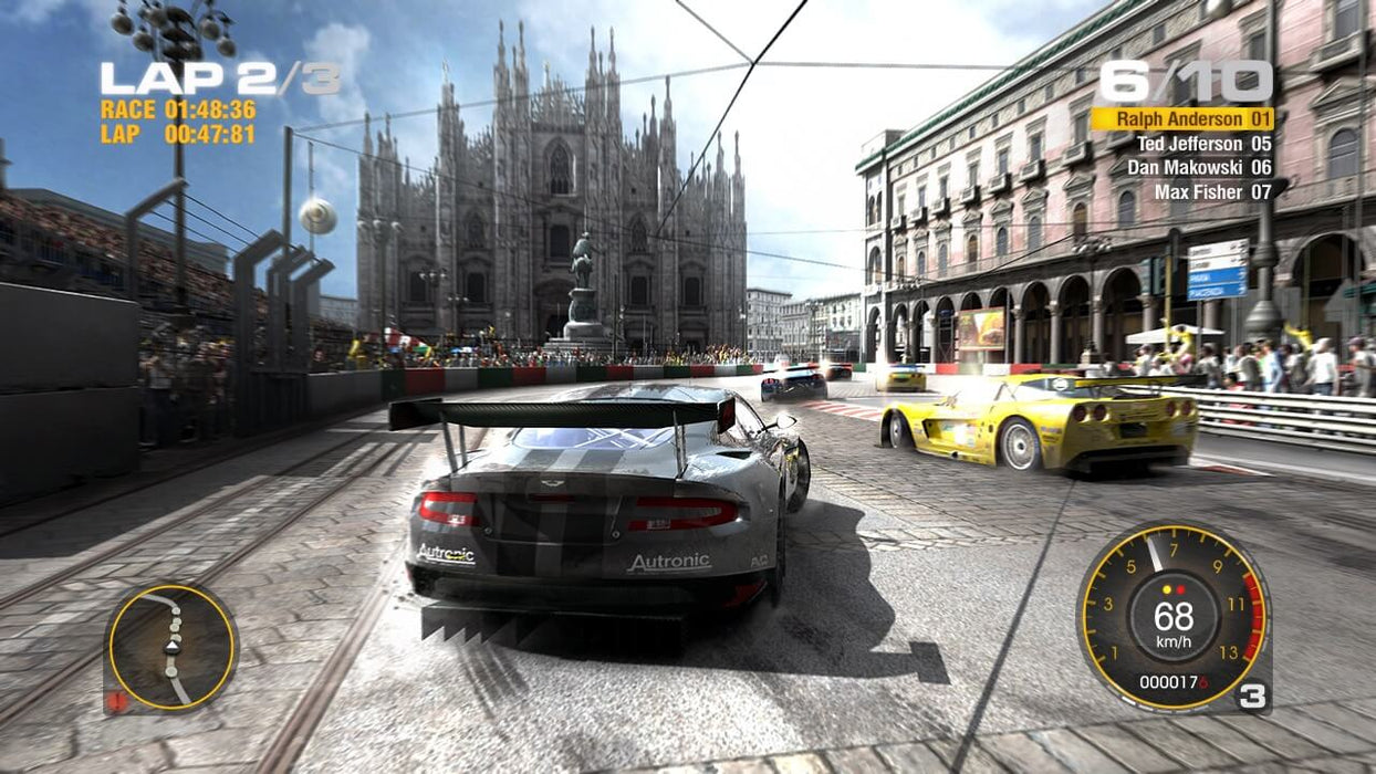 Gameplay screenshot - GRID 2 PC Steam gameplay featuring a competitive race through the streets of Milan, with iconic landmarks and cheering spectators lining the track. Push your limits—purchase your GRID 2 activation key instantly at RushGame.co