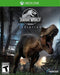 Box art for Jurassic World Evolution on Xbox One, showcasing a roaring T-Rex in a stormy dinosaur enclosure. Buy your Xbox One CD key now at RushGame.co and unleash your creativity in building and managing the ultimate dinosaur park