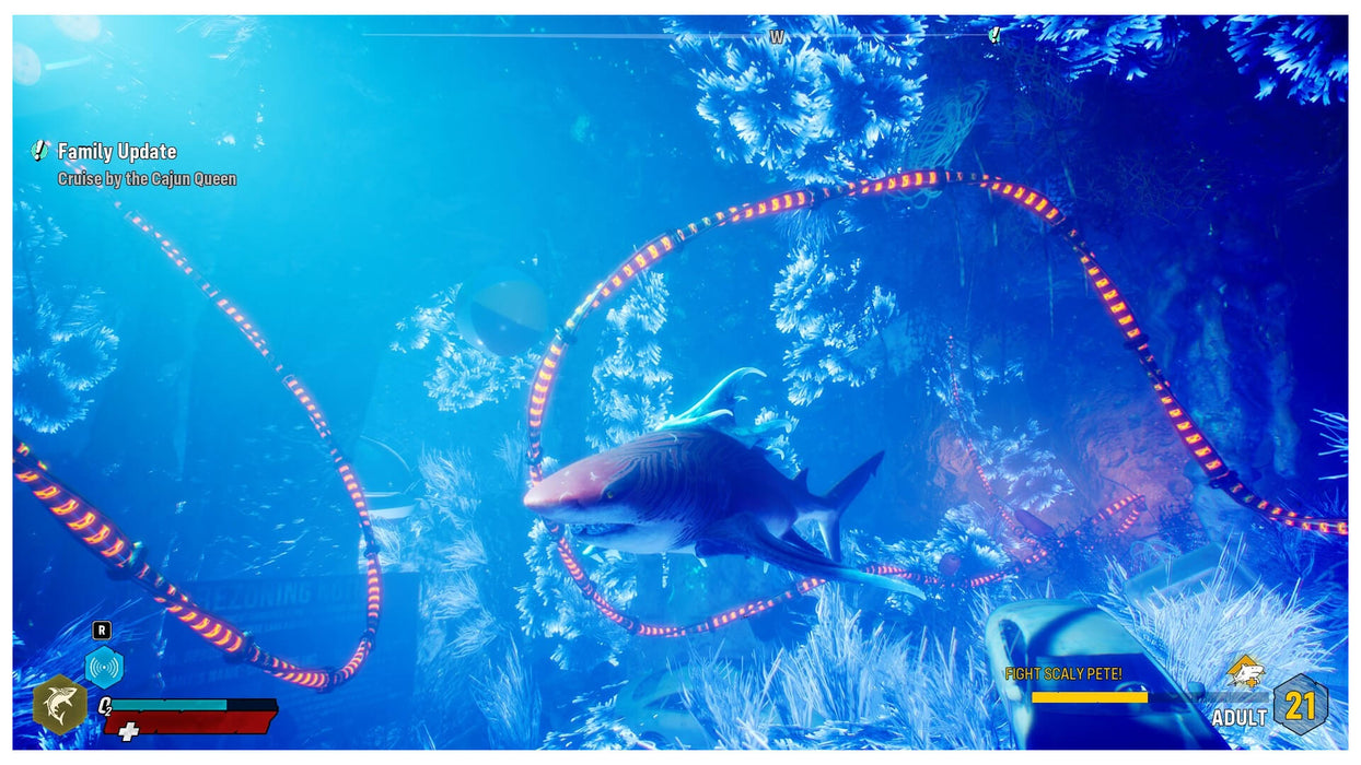 In-game screenshot from Maneater Apex Edition on PC, showing a shark navigating a brightly lit underwater cave filled with glowing coral and electric cables. Explore the aquatic world and dominate the ocean—available now at RushGame.co