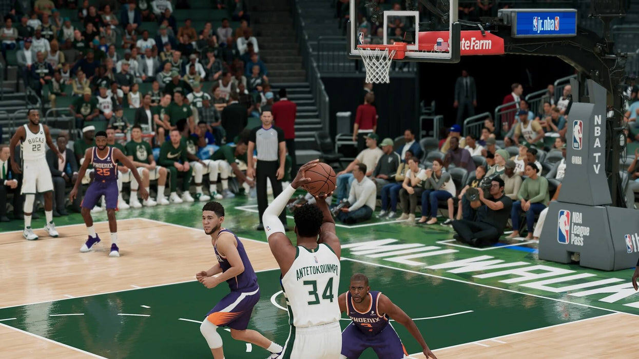 NBA 2K22 gameplay featuring Giannis Antetokounmpo preparing a shot for the Milwaukee Bucks against the Phoenix Suns defense. Experience realistic basketball action with NBA 2K22 on Xbox Series X/S. Buy game keys at RushGame.co