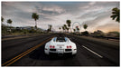 White Bugatti speeding along a coastal highway with a ferris wheel in the background in Need for Speed Hot Pursuit Remastered. Purchase your Nintendo Switch CD Key for NFS Hot Pursuit at RushGame.co