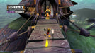 In-game screenshot from Rayman 3: Hoodlum Havoc on PC GOG, showing Rayman crossing a wooden bridge towards an enemy target. Explore vibrant levels with your Rayman 3 CD key from RushGame.co