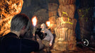 Leon S. Kennedy aiming at an enemy wielding a torch inside a glowing cavern in Resident Evil 4 (2023) Deluxe Edition. Purchase the PC Steam CD Key now at RushGame.co and dive into the reimagined horror